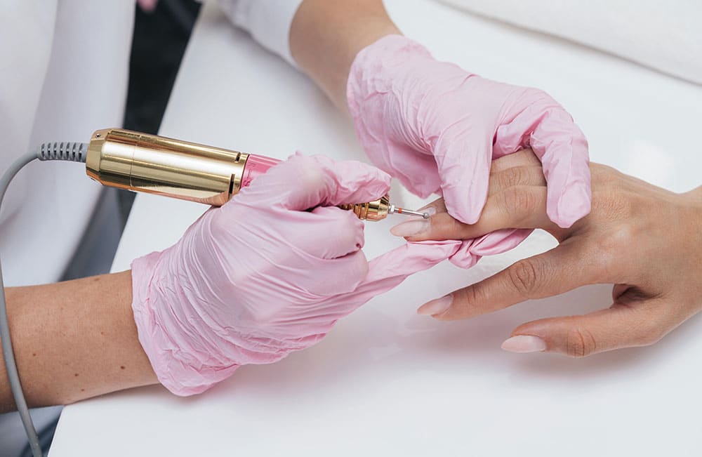Técnica de manicura rusa realizada con torno y herramientas profesionales