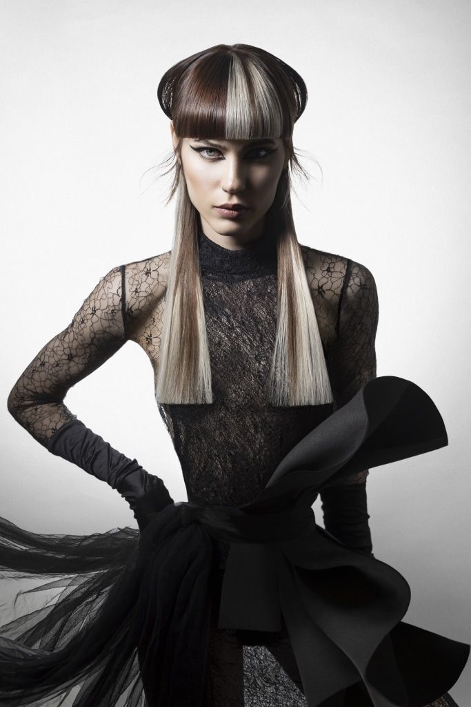 Mujer con peinado editorial geométrico y flequillo marcado, vestida de negro sobre fondo claro